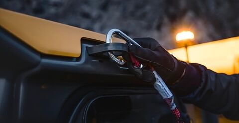 正在将安全带固定到沃尔沃铰接式卡车上的手部特写