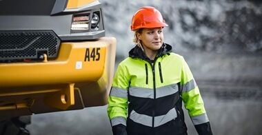 一名驾驶员站在A45沃尔沃铰接式卡车的车头旁边