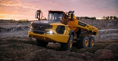 日落时分，一辆沃尔沃A45铰接式卡车在采石场的崎岖地形上行驶