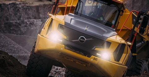 一辆沃尔沃A45铰接式卡车在崎岖地形上行驶时，车身呈一定角度倾斜