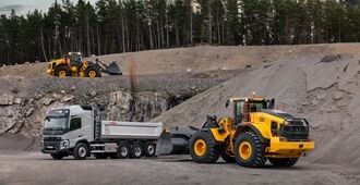 Two Volvo L150 wheel loaders working in a quarry environment alongside a Volvo truck