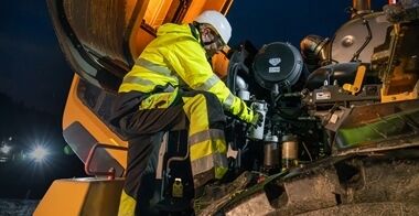 Volvo wheel loader being serviced by technician at night