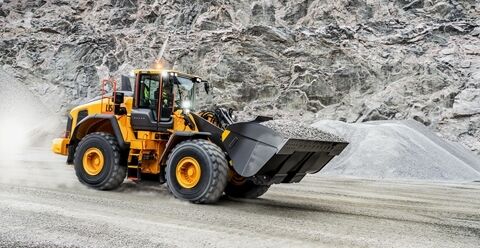Volvo L150 wheel loader travelling downhill with full bucket in quarry environment
