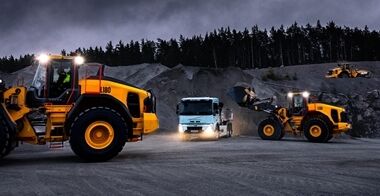 Volvo L150 wheel loader and Volvo L180 wheel loader loading a Volvo FMX truck at night in a quarry