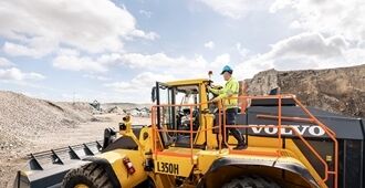 Back side of the L350H Volvo wheel loader showing large orange handrails.