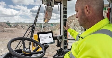 An operator switching on the fuel efficiency mode on a L350H wheel loader.