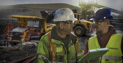 两名团队成员正在查看沃尔沃工地模拟系统数据，以优化机械、车队和工地布置。